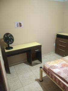 马卡埃Residencial Barbosa - Apto 302的一间客房配有书桌和一张位于客房内的床。