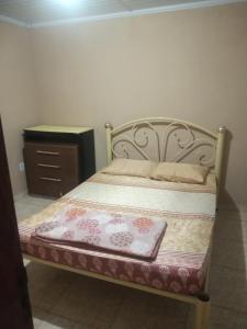 马卡埃Residencial Barbosa - Apto 302的一张床位,房间配有梳妆台和床罩,西德克斯西德克斯