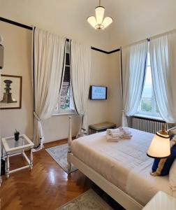 佛罗伦萨纳迪别墅迪颇卡公寓酒店的一间卧室配有一张带灯的床和两个窗户