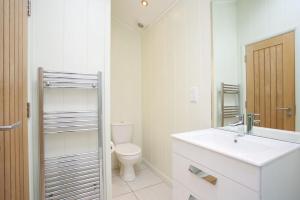 克里夫Braidhaugh Holiday Lodge and Glamping Park的白色的浴室设有卫生间和水槽。