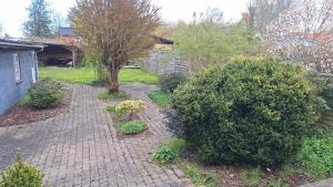 凯隆堡Room in Ubby (Near Kalundborg)的一个带灌木和砖砌走道的花园
