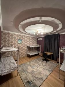 阿拉木图Хостел Aspan的客房设有几张双层床和一张桌子。