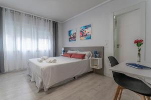 萨拉曼卡Hotel Gabriel y Galán的一间卧室配有带白色床单和红色枕头的床。