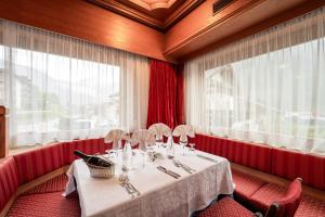 坎皮泰洛迪法萨葛罗曼酒店的一间带桌子和窗户的用餐室