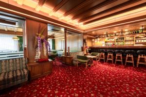坎皮泰洛迪法萨葛罗曼酒店的一间设有椅子和红地毯的酒吧的客房