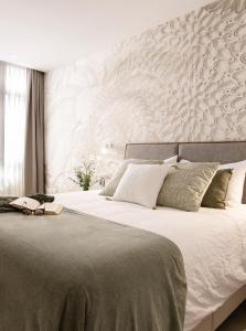 大加那利岛拉斯帕尔马斯Las Canteras con Alma的卧室配有一张白色墙壁的大床