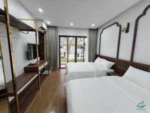 Cái RồngRosa Villa - Sonasea Vân Đồn的一间酒店客房,设有两张床和电视
