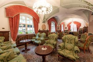 卡纳泽伊Hotel Dolomiti Schloss的客厅配有椅子和吊灯。
