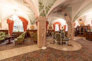 卡纳泽伊Hotel Dolomiti Schloss的客厅设有拱门、椅子和桌子