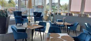 卡罗维发利彩虹膳食公寓酒店的餐厅设有蓝色的椅子和桌子以及窗户。