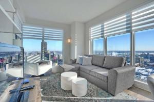 蒙特利尔Spectacular Skyline Views - Downtown Montreal - Luxury Condo & Penthouse的带沙发、椅子和窗户的客厅