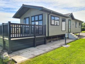 LlanddulasVictory Lodge 2 Bedroom - Sleeps 6 - Bron-Y-Wendon Holiday Park的绿色的小房子,设有大甲板