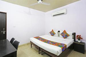 新德里Twamev Punjabi Bagh的一间带一张床铺的卧室,位于带天花板的房间内
