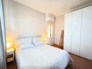 巴韦诺LA CASA GIALLA的白色的卧室设有白色的床和窗户。
