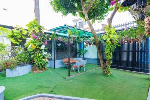 头顿433 Villa Hồ Bơi Gần Biển Bãi Sau - Free Karaoke的花园设有长凳、桌子和树木