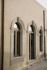 阿卡尼斯Manili Boutique Suites & Villas的建筑一侧的两扇拱形窗户