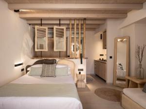 阿卡尼斯Manili Boutique Suites & Villas的卧室配有一张白色大床和镜子