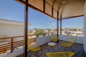圣地亚哥Gran Pacifica Beach Resort & Homes的大楼内的阳台配有黄色的桌椅