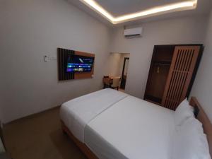 日惹Griya Endika Syariah的一间卧室配有一张床和一台平面电视