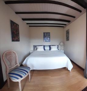 ChindrieuxLACUSTRA的卧室配有白色的床和椅子
