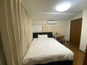 东京TOKYO池袋家族連れ4DKの子供連れ５星　的卧室配有一张白色大床和一张书桌