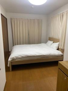 东京TOKYO池袋家族連れ4DKの子供連れ５星　的一间卧室配有一张带白色床单的大床
