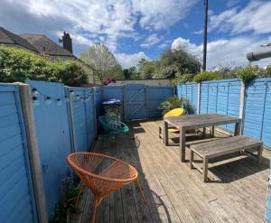 KentBarnacle Drift - a stylish Whitstable cottage的一个带桌椅和围栏的庭院