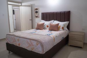 巴耶杜帕尔APARTAMENTO - AIRE ACONDICIONADO的卧室配有一张带粉红色枕头的大床