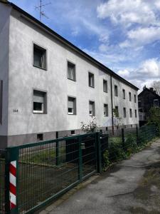 波鸿FlattyOne Ruhrgebiet - Schlafkomfort und Anbindung - neu renoviert的前面有栅栏的白色建筑