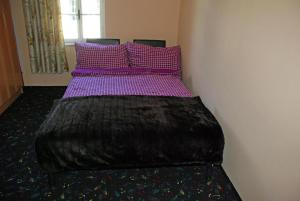 Mala NedeljaRuhig gelegenes Ferienhaus für erholsamen Urlaub auf dem Land inmitten der Thermenregion Sloweniens的一张带紫色床单和紫色枕头的床
