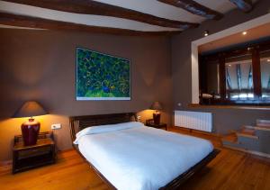 Sant Pau dʼOrdal玛西亚奥利维拉酒店的卧室配有一张大床,墙上挂有绘画作品