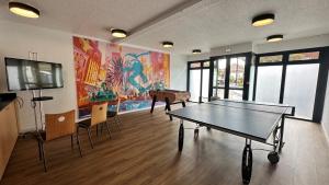 勒布尔热基里亚德布杰中央世博园酒店的一间设有乒乓球桌和电视的客房