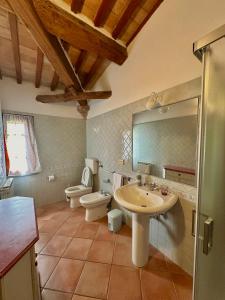 圣吉米纳诺农庄卡萨酒店的一间带水槽、卫生间和镜子的浴室