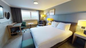 爱丁堡Holiday Inn Edinburgh Zoo, an IHG Hotel的配有一张床和一张书桌的酒店客房
