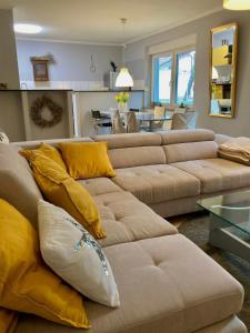 萨格勒布The Lovely Garden House的客厅配有棕色沙发和黄色枕头