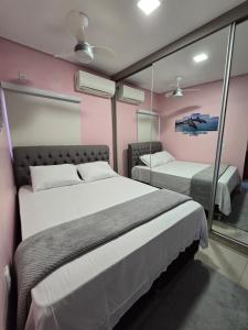 库亚巴Casa Rosa的一间卧室配有两张床和镜子