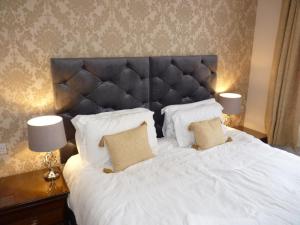 欧克汉普敦Seven Stars - Bed & Breakfast & Restaurant的一间卧室配有一张带两盏灯的大型白色床。