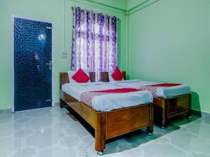 卡齐兰加OYO Flagship Bonfire Kaziranga Resort的带窗户的客房内设有两张单人床。
