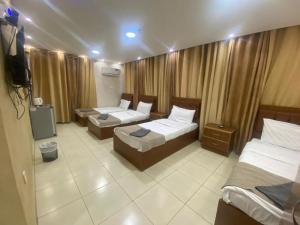 亚喀巴Zuwwar Aqaba的酒店客房设有两张床和电视。