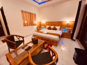 阿姆利则Sumitra Guest House的酒店客房带一张床、一张桌子和椅子
