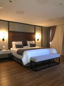 伊瓜苏Cataratas Park Hotel e Eventos的一间大卧室,配有一张大床和木制床头板