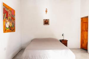 蒂尔卡拉Cabañas Tilcara Taki的白色的卧室配有一张床,墙上挂着一幅画