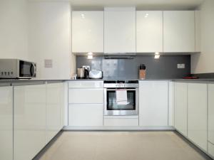 伦敦塔山服务式公寓的白色的厨房配有白色橱柜和电器