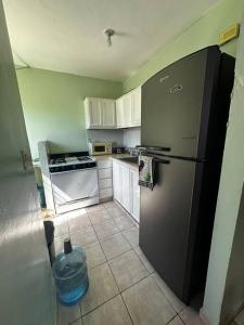纳瓜casa nagüera的厨房配有黑冰箱和白色橱柜。