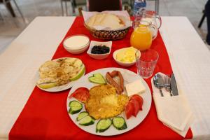 培拉特Hotel Boutique BUZI的一张桌子,上面放着一盘早餐食品和橙汁