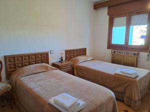 OsmaWAXSIMA Burgo de Osma的客房设有两张床和窗户。