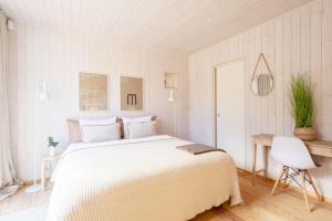 海门林纳Stay North - Villa Katajala的白色卧室配有一张大床和椅子