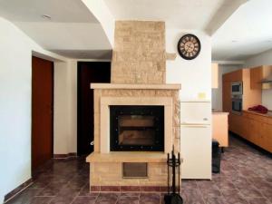 梅杜林Skajla Apartments的客厅设有石制壁炉及时钟