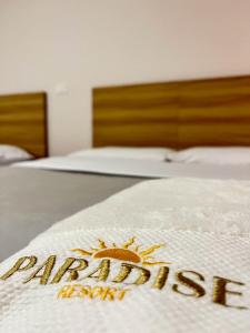 Los SantosParadise Resort的在酒店房间床上的标牌
