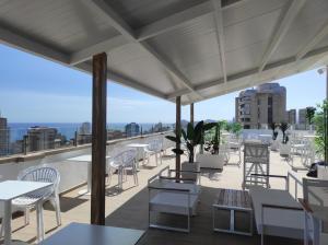 贝尼多姆Flamingo Beach Resort - Adults Recommended的屋顶上带桌椅的天井